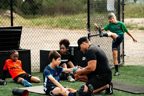 Performance Lab coach giving hands-on movement-quality feedback during a screening