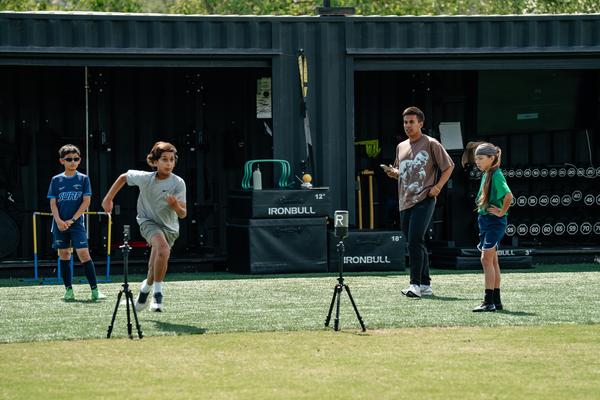 Athlete sprinting through laser timing gates capturing speed data at Performance Lab