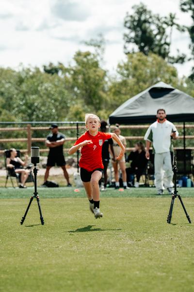 Young athlete performing a broad-jump power test measured on a jump mat